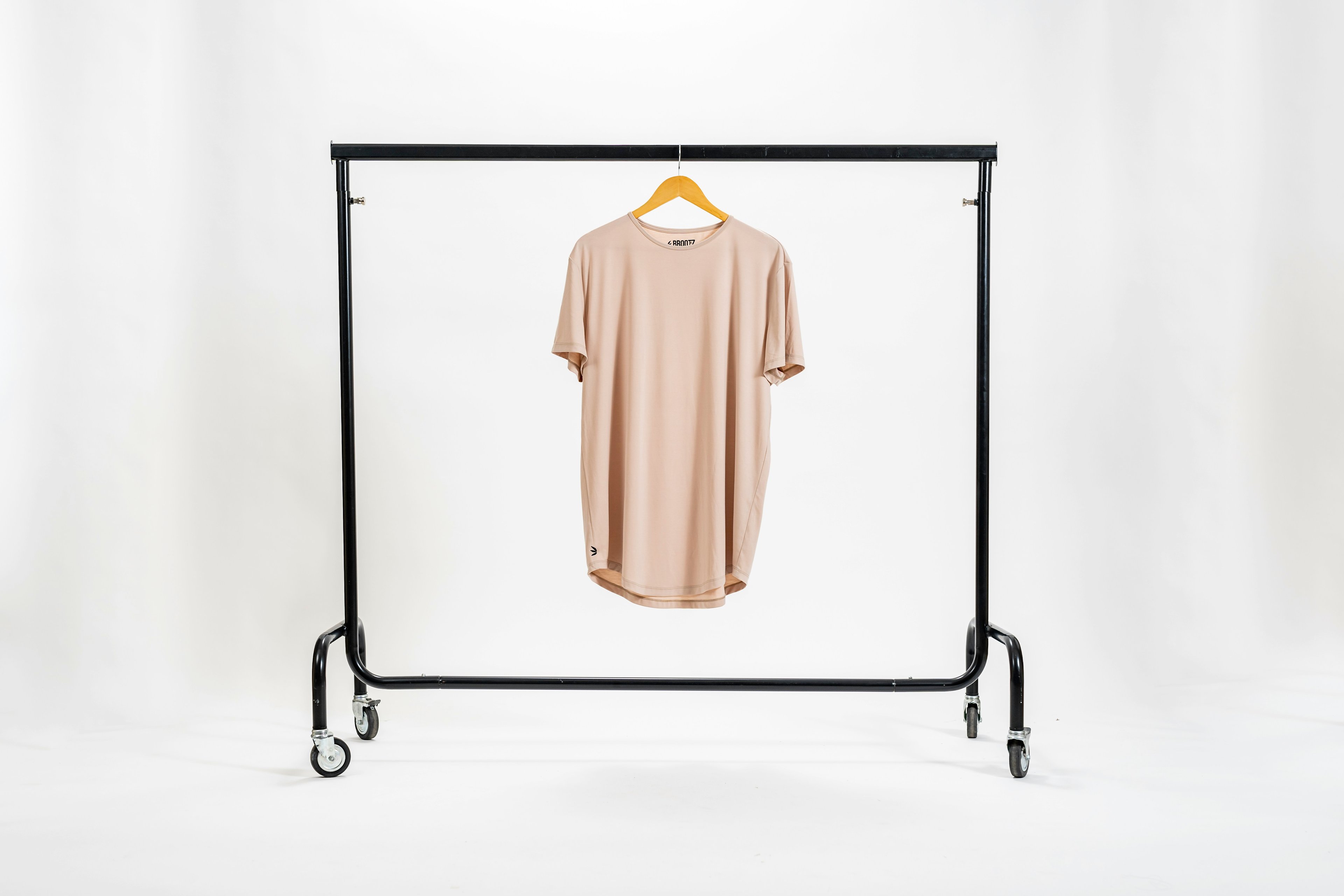 A beige t-shirt on a slightly off background that looks cheap.
