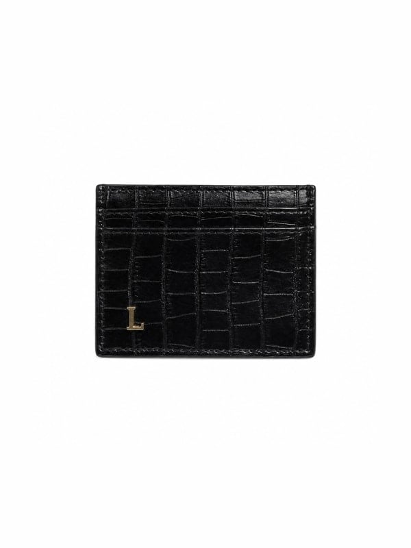 Black croc-embossed leather card holder with a small gold L charm at the bottom edge, shown front-facing on a white background.