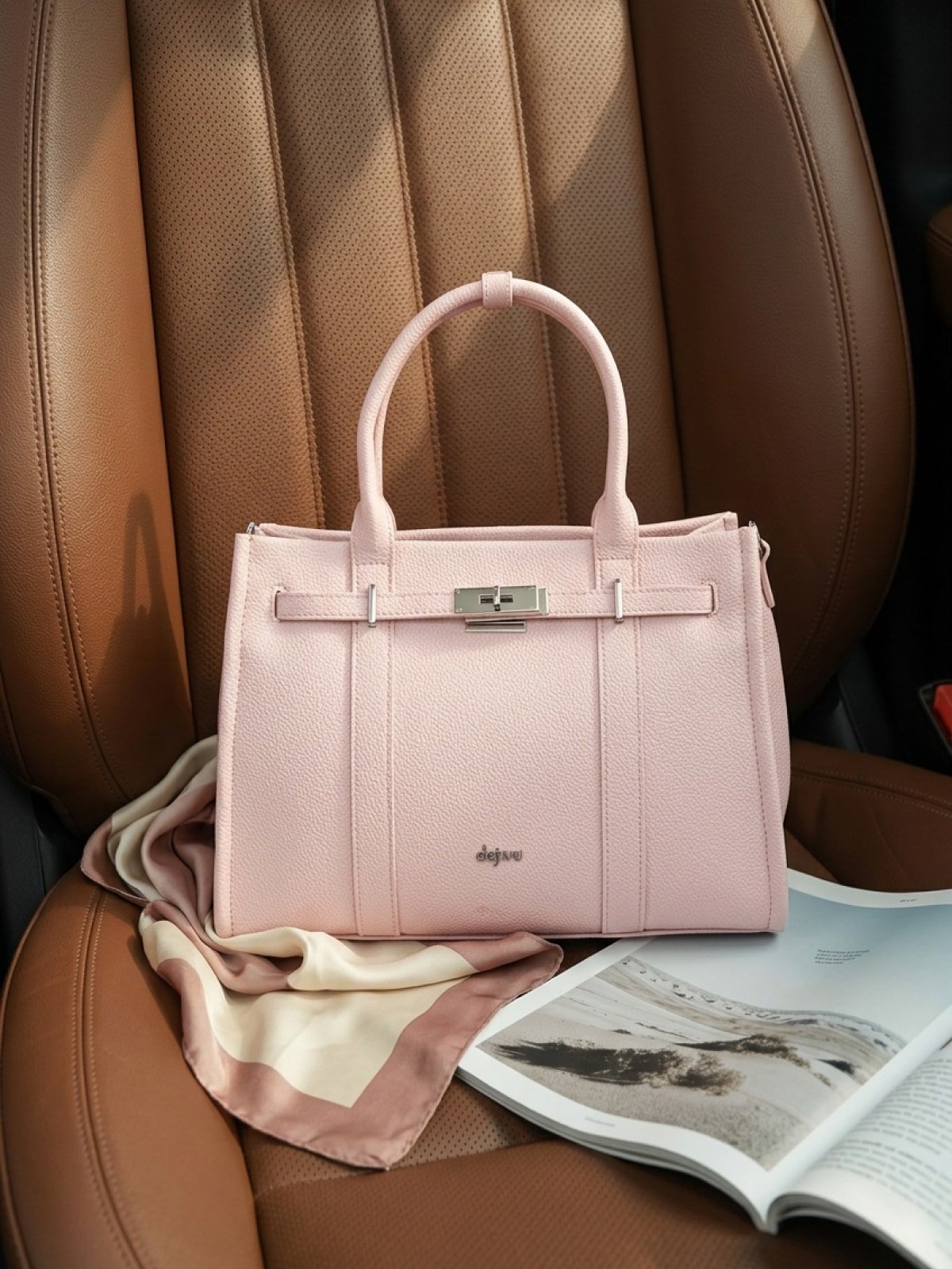 Pale pink leather tote bag styled on a brown leather car seat next to a silk scarf and an open magazine, in warm natural light.