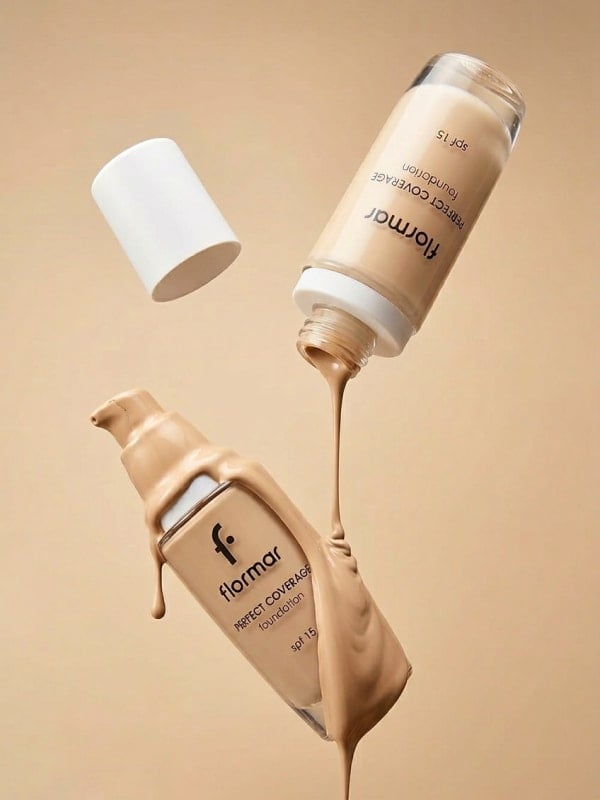 Flormar Perfect Coverage foundation pump bottle suspended mid-air with thick beige liquid pouring out across a warm beige paper backdrop.