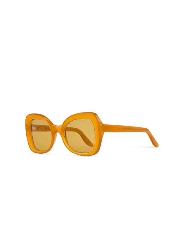Oversized butterfly sunglasses with translucent orange acetate frames and yellow tinted lenses, shown in three-quarter view on a white background.