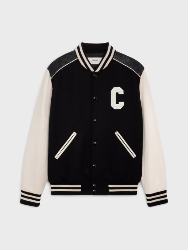 Black and cream Celine varsity jacket with a white C letter patch, leather sleeves, and striped trims, displayed flat on a light background.