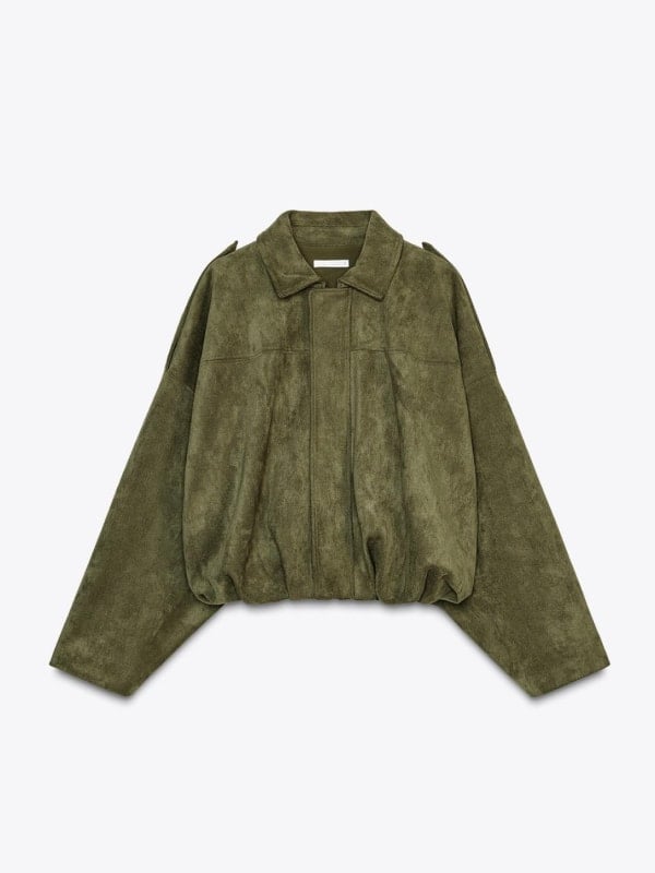 Olive green suede bomber jacket with a collar and zip front, displayed flat on a deep green background.