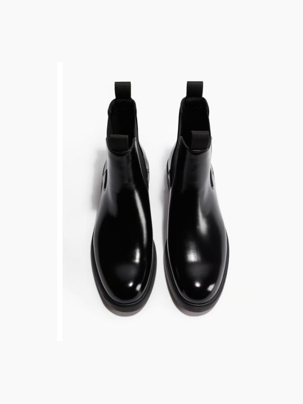 Pair of glossy black leather Chelsea boots, shown top-down on a white background.