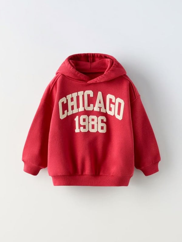 Red hoodie with ‘Chicago 1986’ print, displayed flat against a light background.
