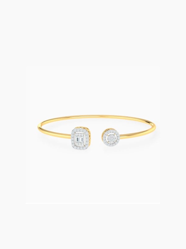 Open-cuff gold bangle bracelet with a pavé emerald-cut crystal at one end and a round pavé crystal at the other, displayed on a light grey background.