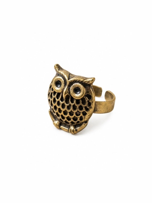 Brass owl-shaped adjustable ring with a textured feathered body and round eyes, shown in three-quarter view on a white background.
