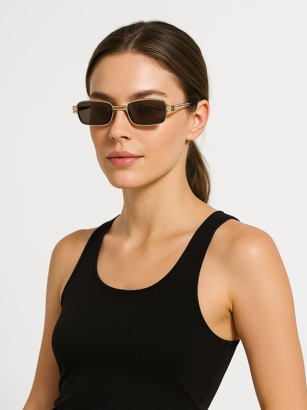 Woman wearing slim rectangular sunglasses with gold frames and a black tank top, posing against a plain white background.