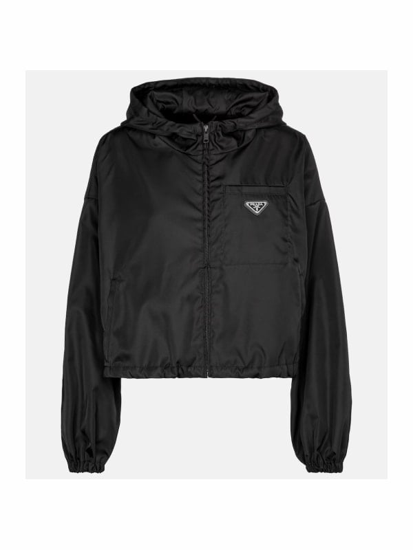 Cropped black Prada nylon hood jacket with triangle logo plaque on the chest pocket, displayed flat on a light grey background.